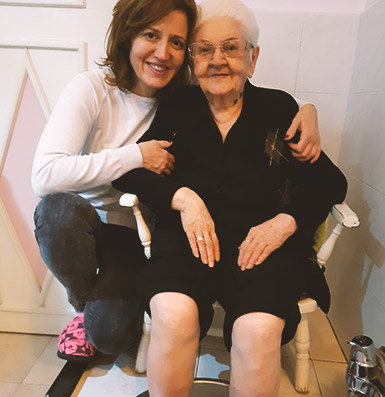 Negovateljica pomaže baki sa higijenom stopala